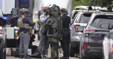 Law enforcement officials dress up in protective gear to investigative an attack on the Pearl Street Mall, Sunday, June 1, 2025, in Boulder, Colo. (AP Photo/David Zalubowski)