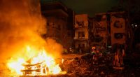 Firefighters and rescue personnel at the site of a fire following a missile attack.