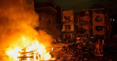 Firefighters and rescue personnel at the site of a fire following a missile attack.