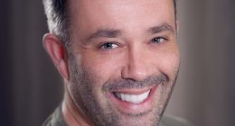 Headshot of a smiling man.