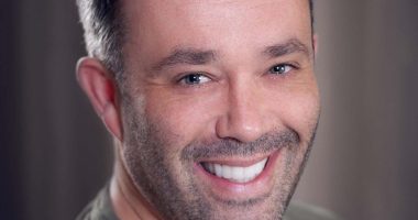 Headshot of a smiling man.