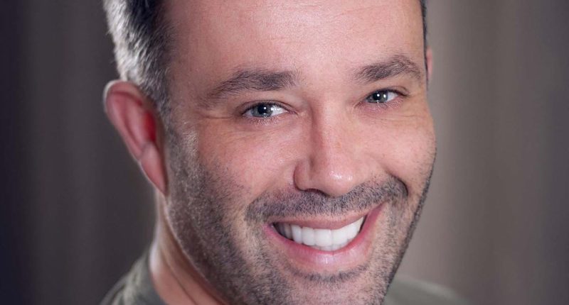 Headshot of a smiling man.