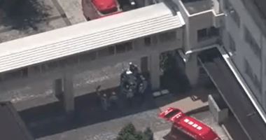 Aerial view of emergency vehicles outside a Japanese high school.