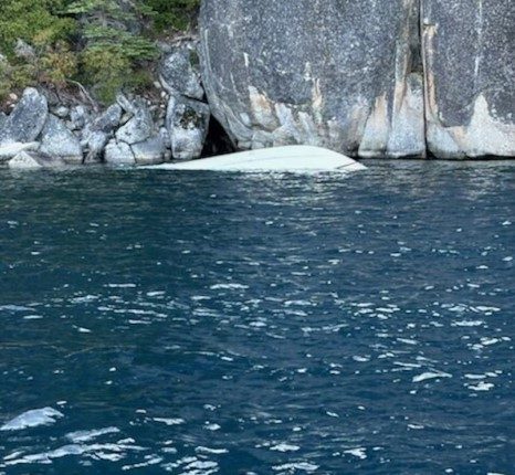 Submerged boat near Lake Tahoe shore.