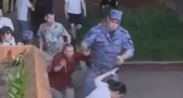 A soldier points a gun at a woman's head during a restaurant brawl.