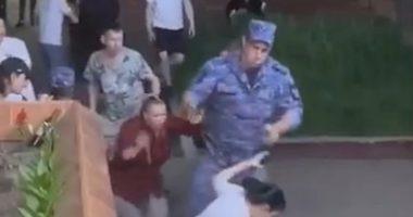 A soldier points a gun at a woman's head during a restaurant brawl.