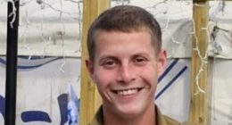 Portrait of a smiling young man in a military uniform.