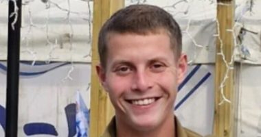 Portrait of a smiling young man in a military uniform.