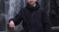 Man standing by a waterfall.