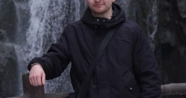 Man standing by a waterfall.