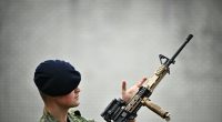 Royal Netherlands Marine Corps member inspecting a weapon.