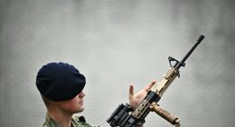 Royal Netherlands Marine Corps member inspecting a weapon.
