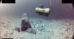 Underwater robot inspecting pipeline.