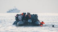 Migrants in an inflatable boat at sea.