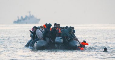 Migrants in an inflatable boat at sea.
