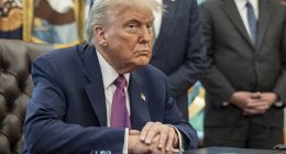 President Donald Trump sitting at a table in the Oval Office.