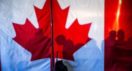 Supporters’ shadows are seen behind a Canadian flag during a campaign rally in Oakville in Ontario