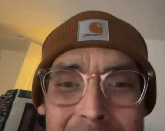 Tanner in a brown beanie and glasses.