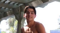 Portrait of a smiling shirtless teenage boy.