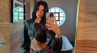 Dua Lipa flaunts her washboard abs in a cropped black leather jacket
