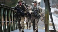US Army paratroopers crossing a bridge.