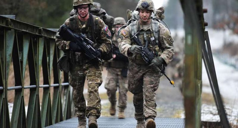 US Army paratroopers crossing a bridge.