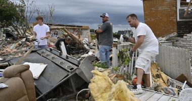 Volunteers help clean up debris from storm damage in the Sunshine Hills neighborhood in London, Ky., Monday, May 19, 2025