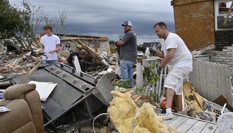 Volunteers help clean up debris from storm damage in the Sunshine Hills neighborhood in London, Ky., Monday, May 19, 2025
