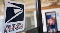 USPS logo on a post office door.