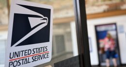 USPS logo on a post office door.