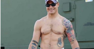 Photo of Travis Decker, showing his tattoos and physique.