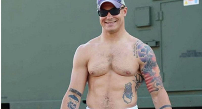 Photo of Travis Decker, showing his tattoos and physique.