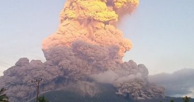 Volcanic eruption plume over a landscape.