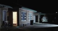 Nighttime view of a house exterior, possibly a crime scene.