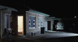 Nighttime view of a house exterior, possibly a crime scene.