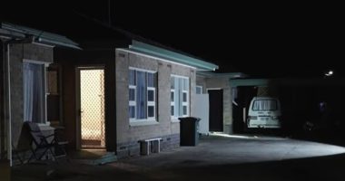 Nighttime view of a house exterior, possibly a crime scene.