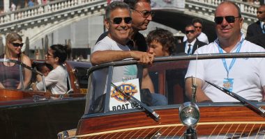 George Clooney, old friend Sandra Bullock and her son Louis cruise through Venice's canals ahead of film festival