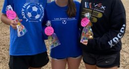 Three girls holding birthday treats, one wearing a Lady Hornet Soccer sweatshirt.