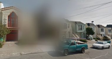 Blurred Google Street View image of houses and a street.
