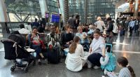 People sit at Hamad international airport after Qatar reopened its airspace