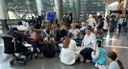 People sit at Hamad international airport after Qatar reopened its airspace