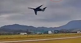 Video still of a plane and helicopter near mid-air collision at an airport.