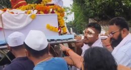 A man carrying his brother's coffin at a funeral procession.
