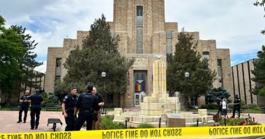 Police officers investigating a scene in front of a courthouse.