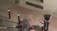 A man being restrained on the ground by another man.