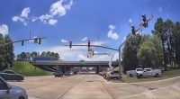 Road crews working on traffic signals at an intersection.