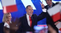 Karol Nawrocki, Polish presidential candidate, giving a victory sign at an election night event.