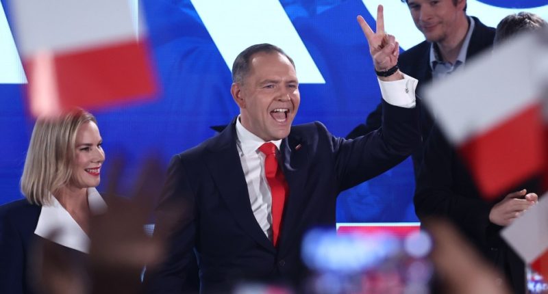 Karol Nawrocki, Polish presidential candidate, giving a victory sign at an election night event.