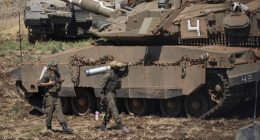 An Israeli soldier carries a shell next to a tank in northern Israel on Friday, September 27.
