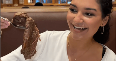 Woman holding a large spoonful of roast beef at Shady Maple Smorgasbord in Pennsylvania.